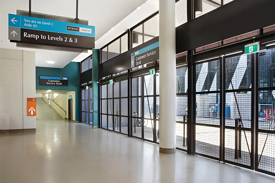 Interior of a public facility showing directional signs and exit doors